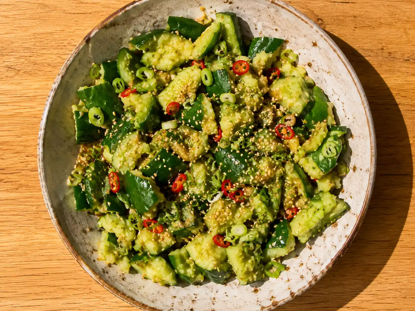 asiatisk gurksallad med krispig gurka, sesamfrön, chili och blank sojadressing i skål
