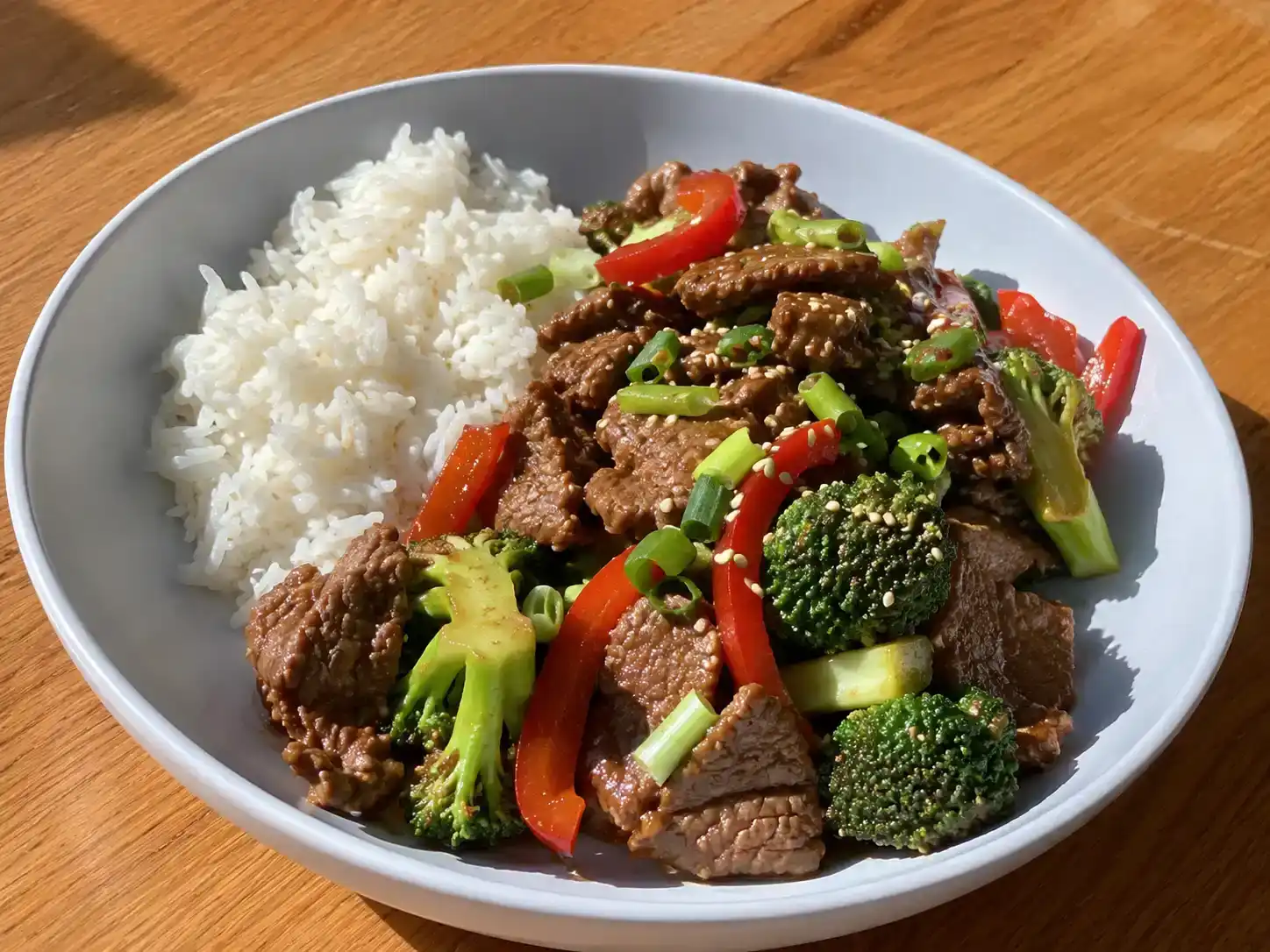 asiatisk lövbiff wok med strimlat kött, broccoli, paprika och salladslök i blank sojasås