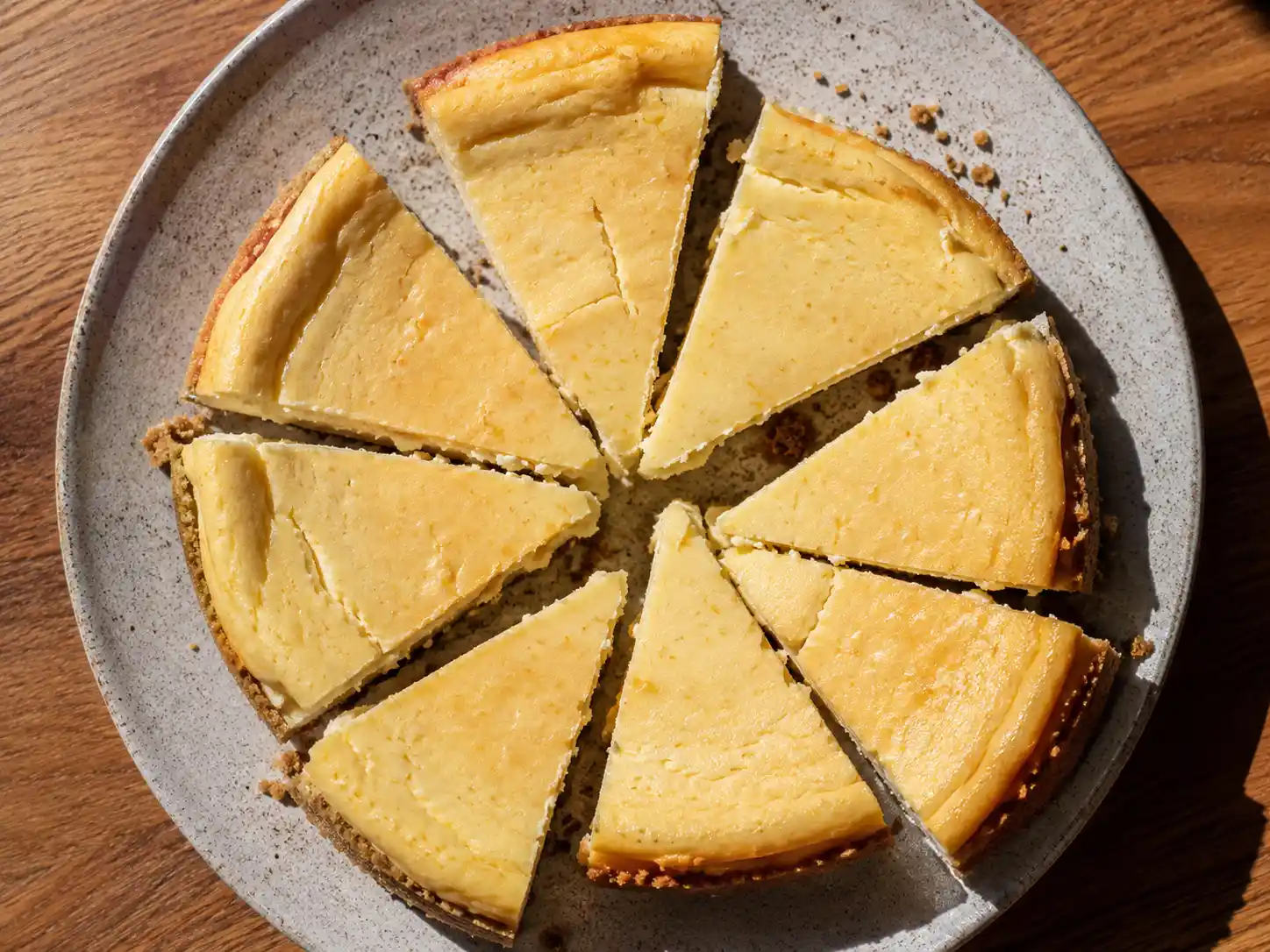 bakad cheesecake med gyllene kexbotten, krämig vaniljfyllning och lätt sprucken hembakad yta