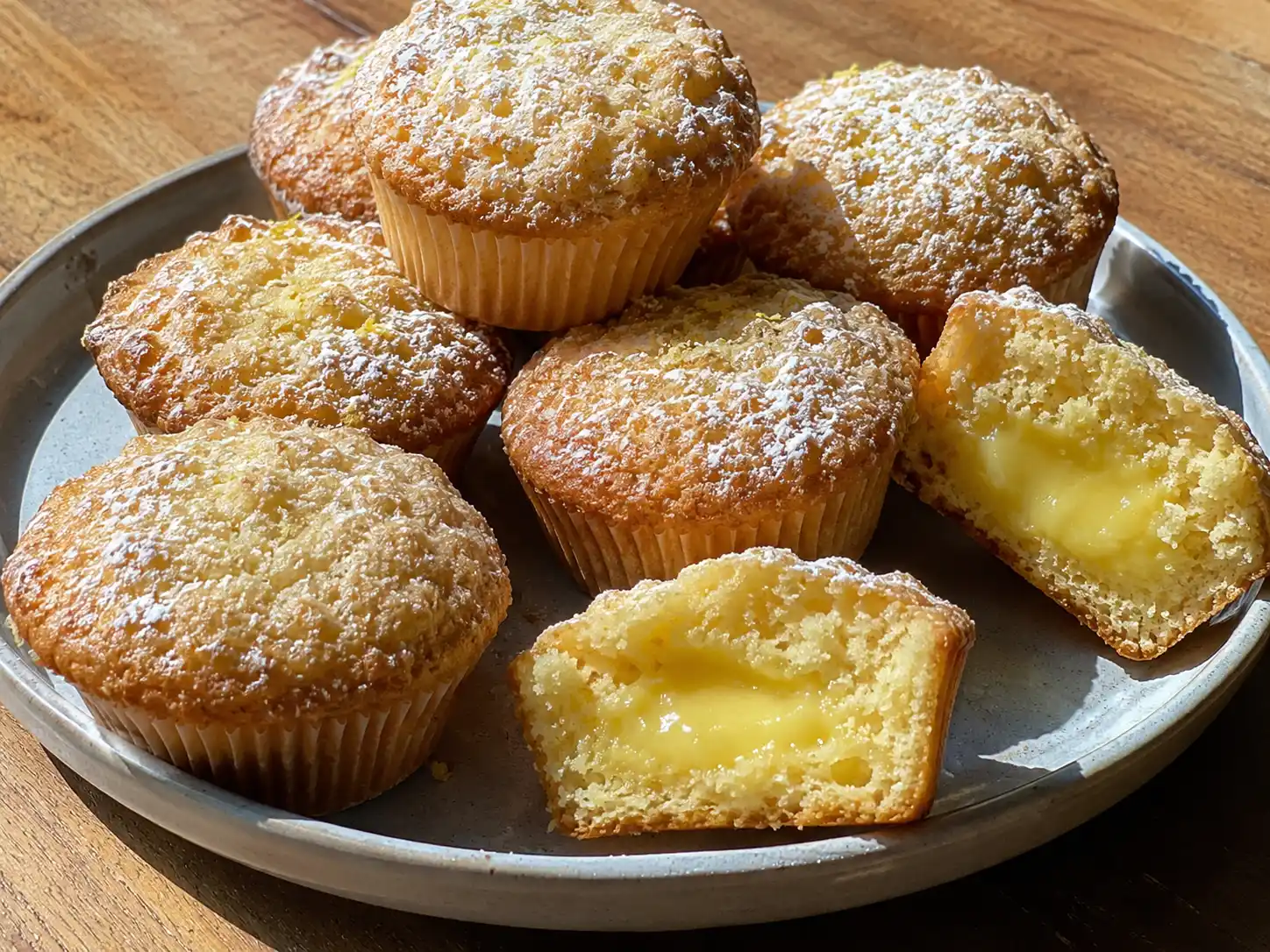 citronmuffins med fyllning på fat med gyllene yta, mjuk smula och synlig citronkräm