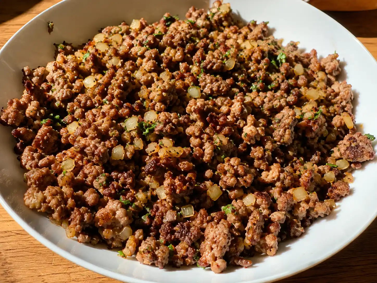 köttfärs i airfryer med brynt smulig färs, gul lök och persilja serverad enkelt på en ljus tallrik