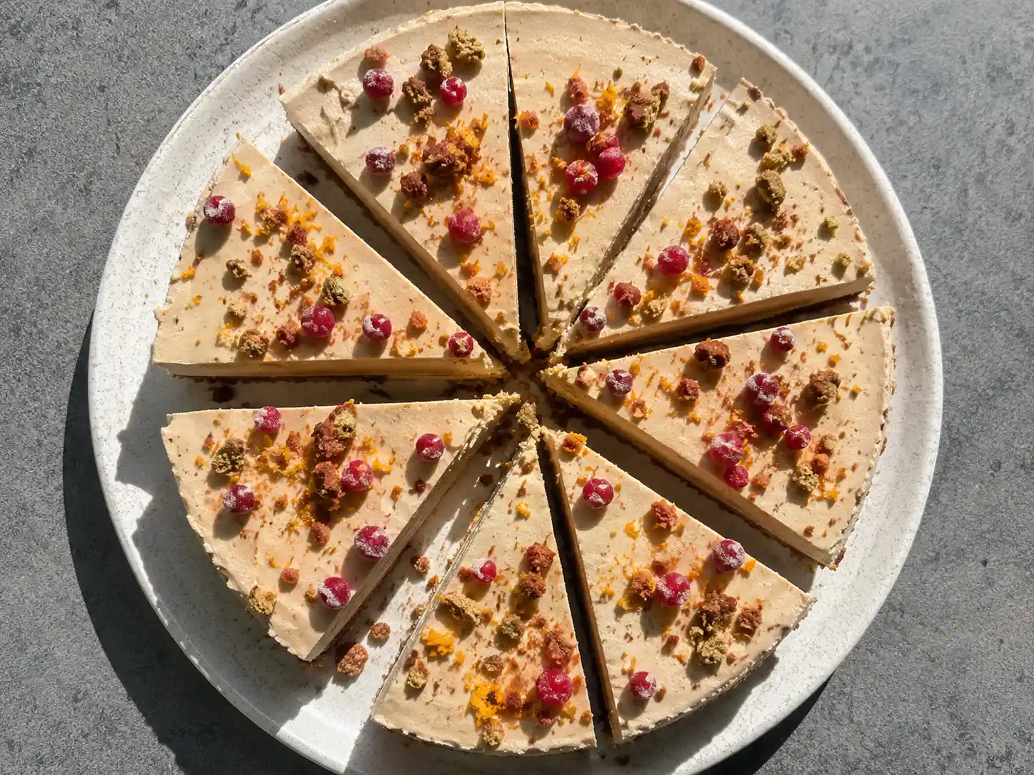 pepparkakscheesecake med pepparkaksbotten, krämig fyllning och lingon på ett enkelt fat