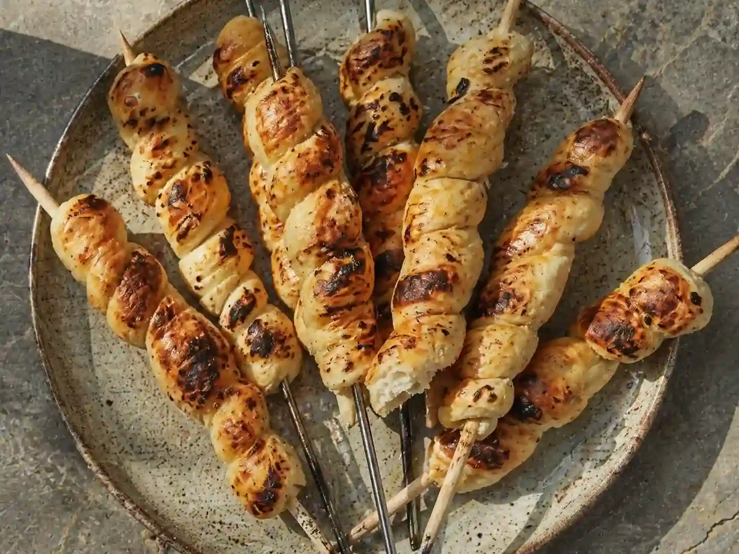 pinnbröd recept med gyllene spiralbröd på grillpinnar, rostade fläckar och mjuk mitt