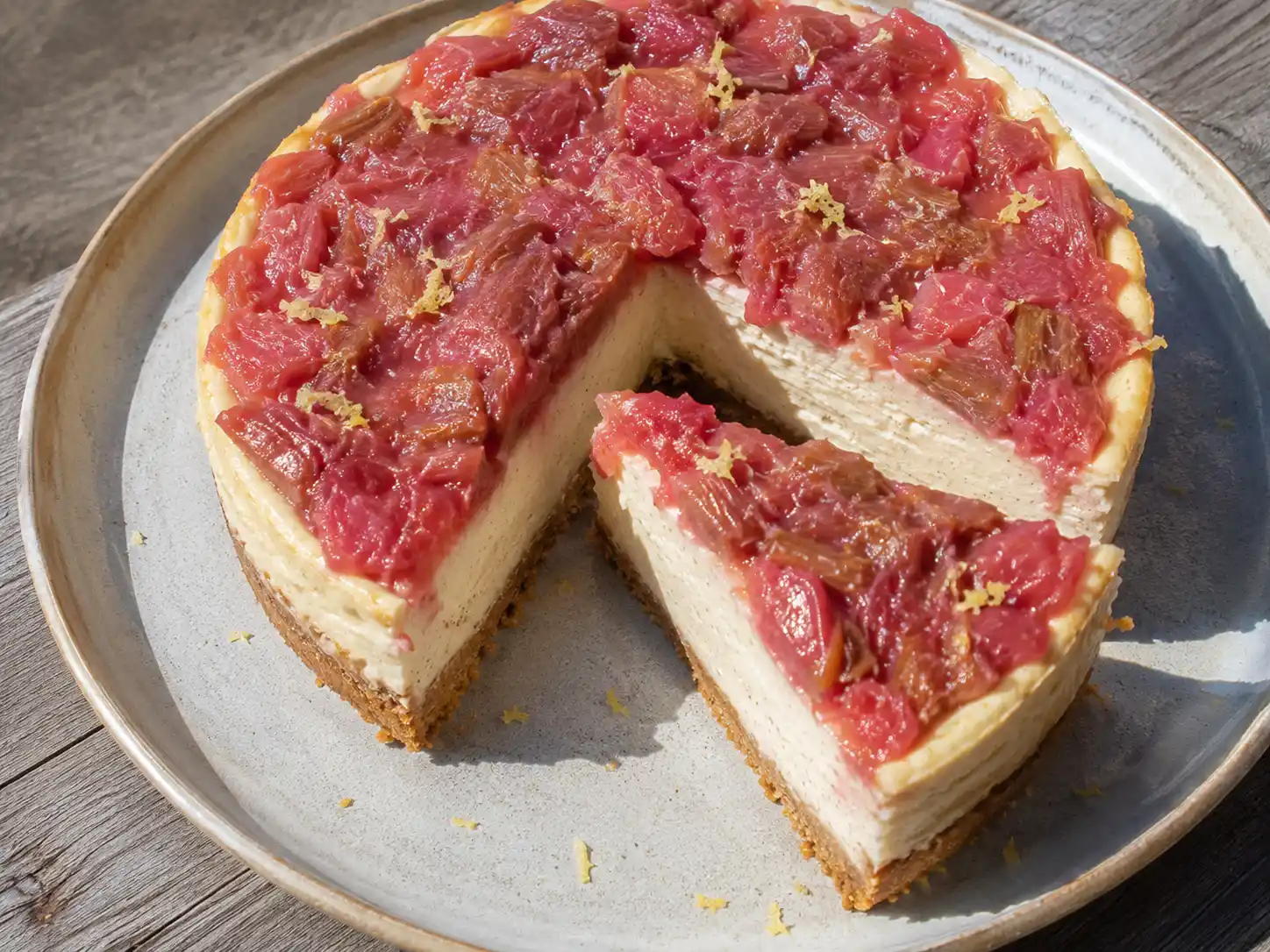 rabarber cheesecake med krämig vaniljfyllning, gyllene kexbotten och rosa rabarberkompott