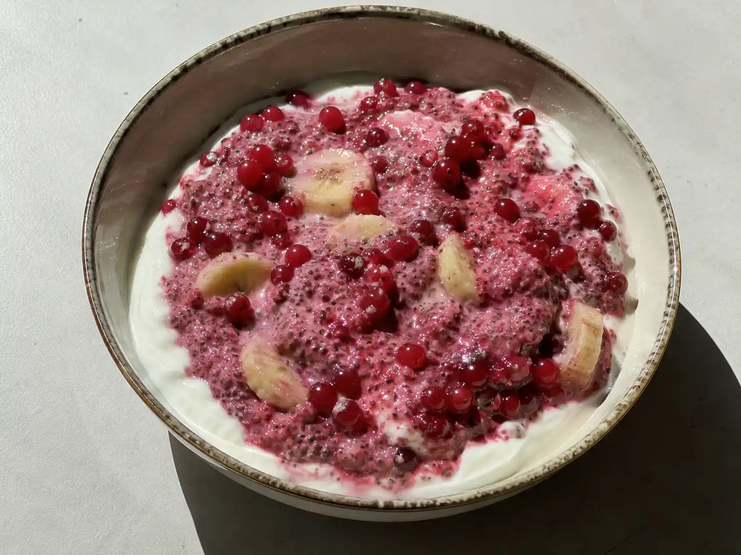 röda vinbär recept utan socker serverat som syrlig bärkräm med yoghurt, chia och färska bär i skål