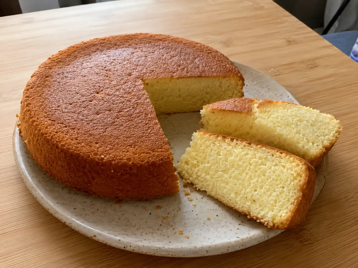 sockerfri sockerkaka på fat, gyllene ovanpå och mjuk i mitten, skuren i skivor i ett ljust hemmakök