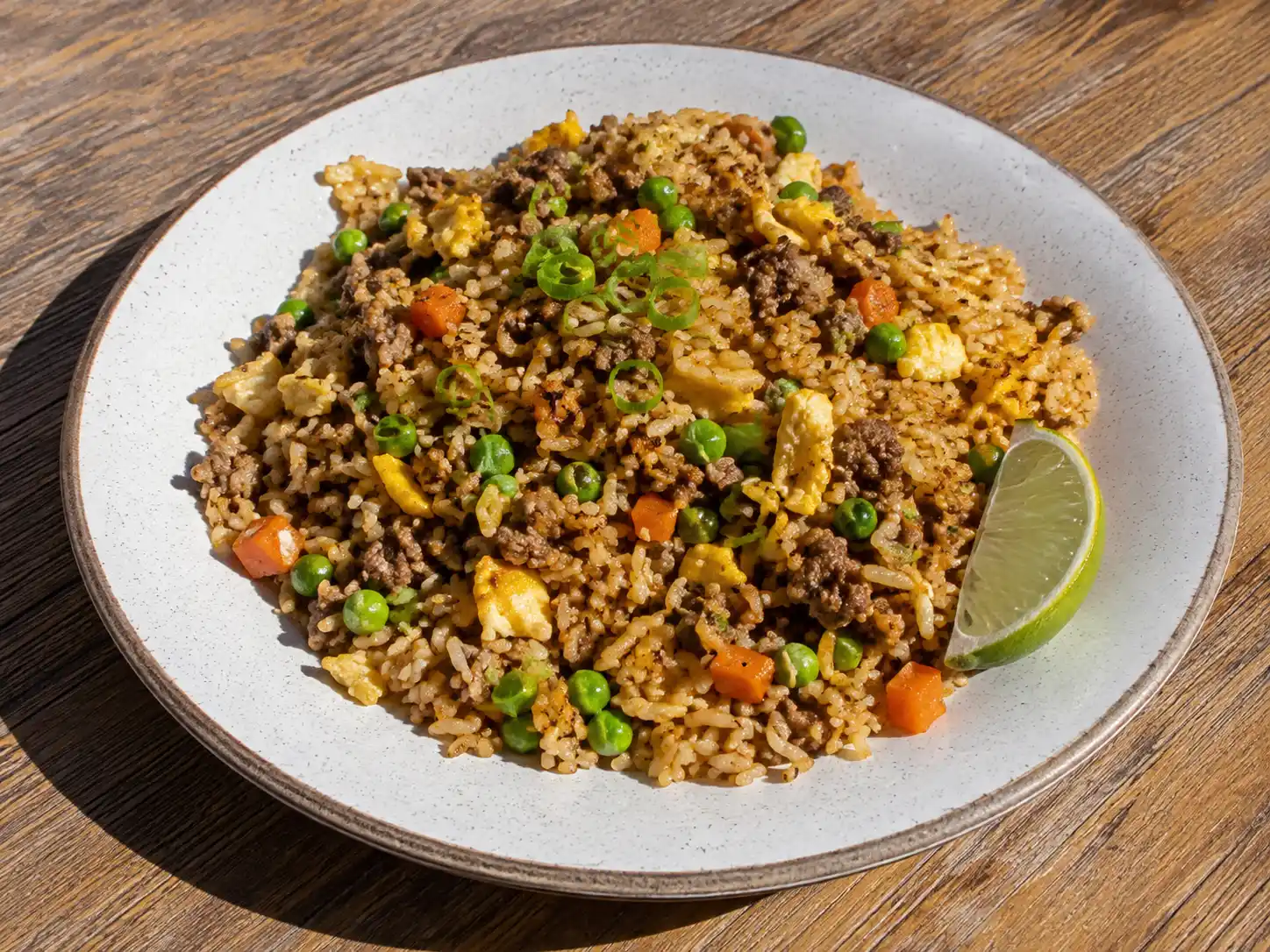 stekt ris med köttfärs med brynt färs, ägg, gröna ärtor och morot serverat direkt ur stekpannan