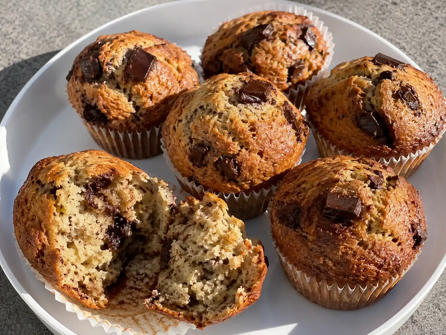 banan choklad muffins på tallrik med mjuk smula, synliga chokladbitar och lätt sprucken gyllene yta