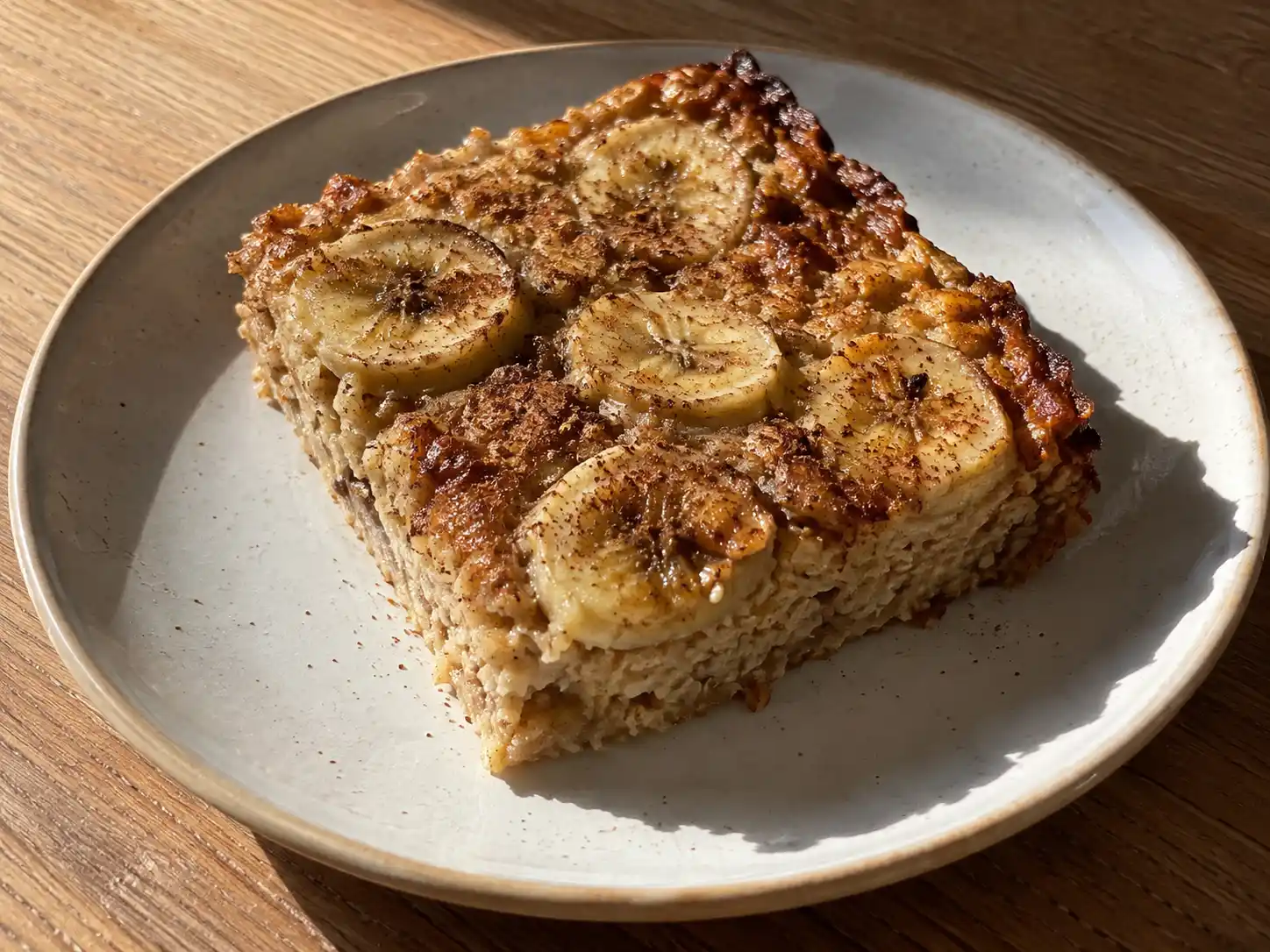 bananpannkaka i ugn med gyllene kanter, mjuk mitt och bakade bananskivor på toppen, skuren i bitar