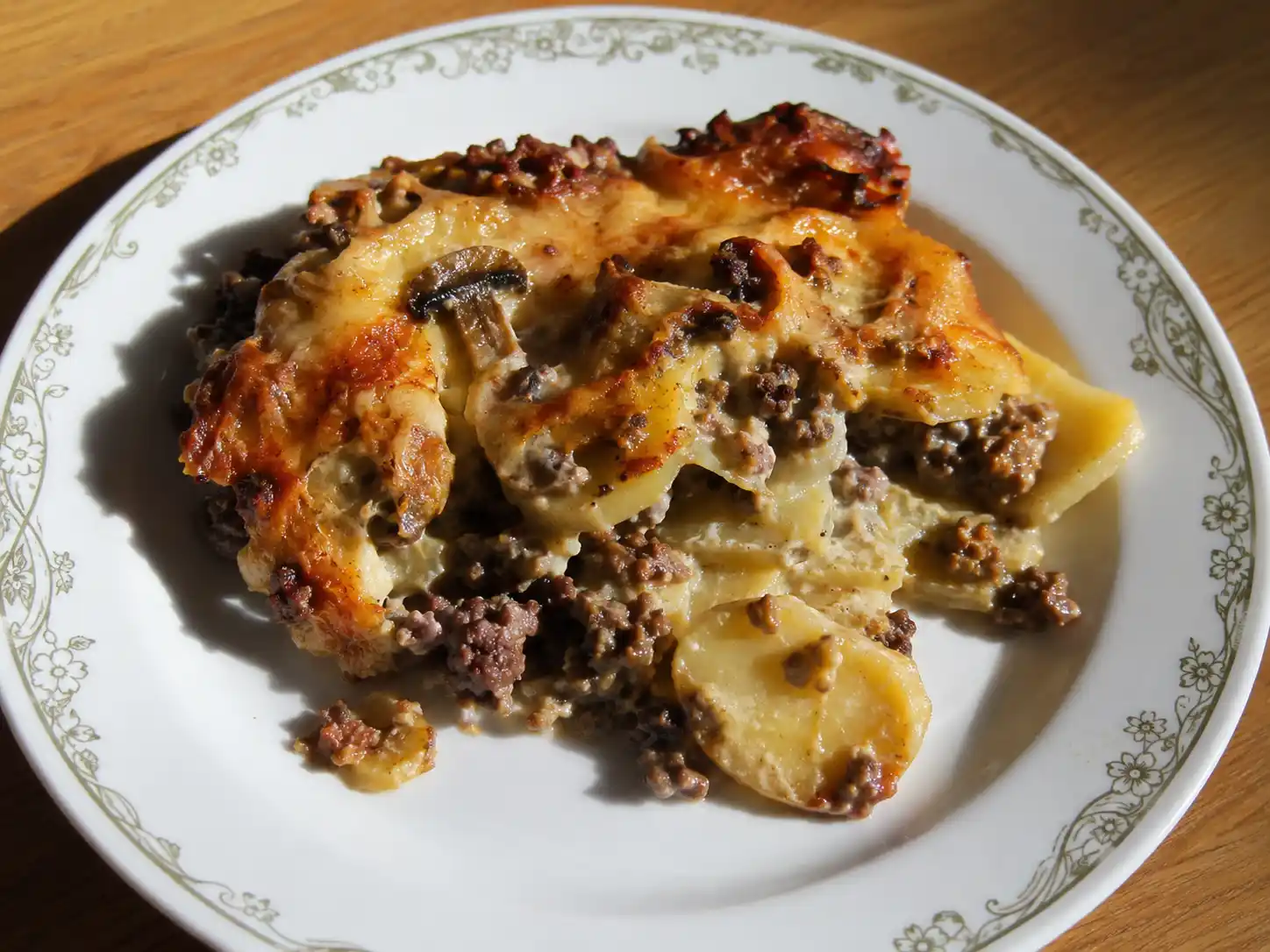 lyxmiddag köttfärs som krämig potatisgratäng med brynt färs, svamp och gyllene ostyta i ugnsform