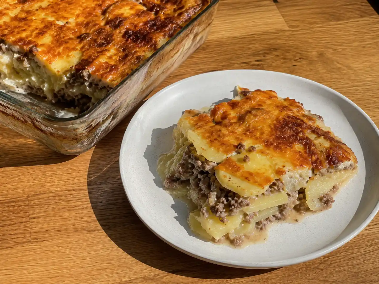 Potatisgratäng med köttfärs med mjuka potatisskivor, mustig färs och gyllene ostyta i en ugnsform