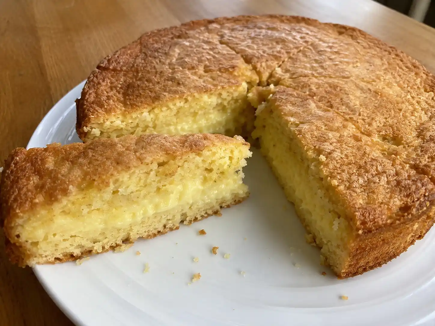 sockerkaka med fyllning på fat, skuren i tjocka bitar med synlig vaniljkräm och gyllene yta från ugnen.