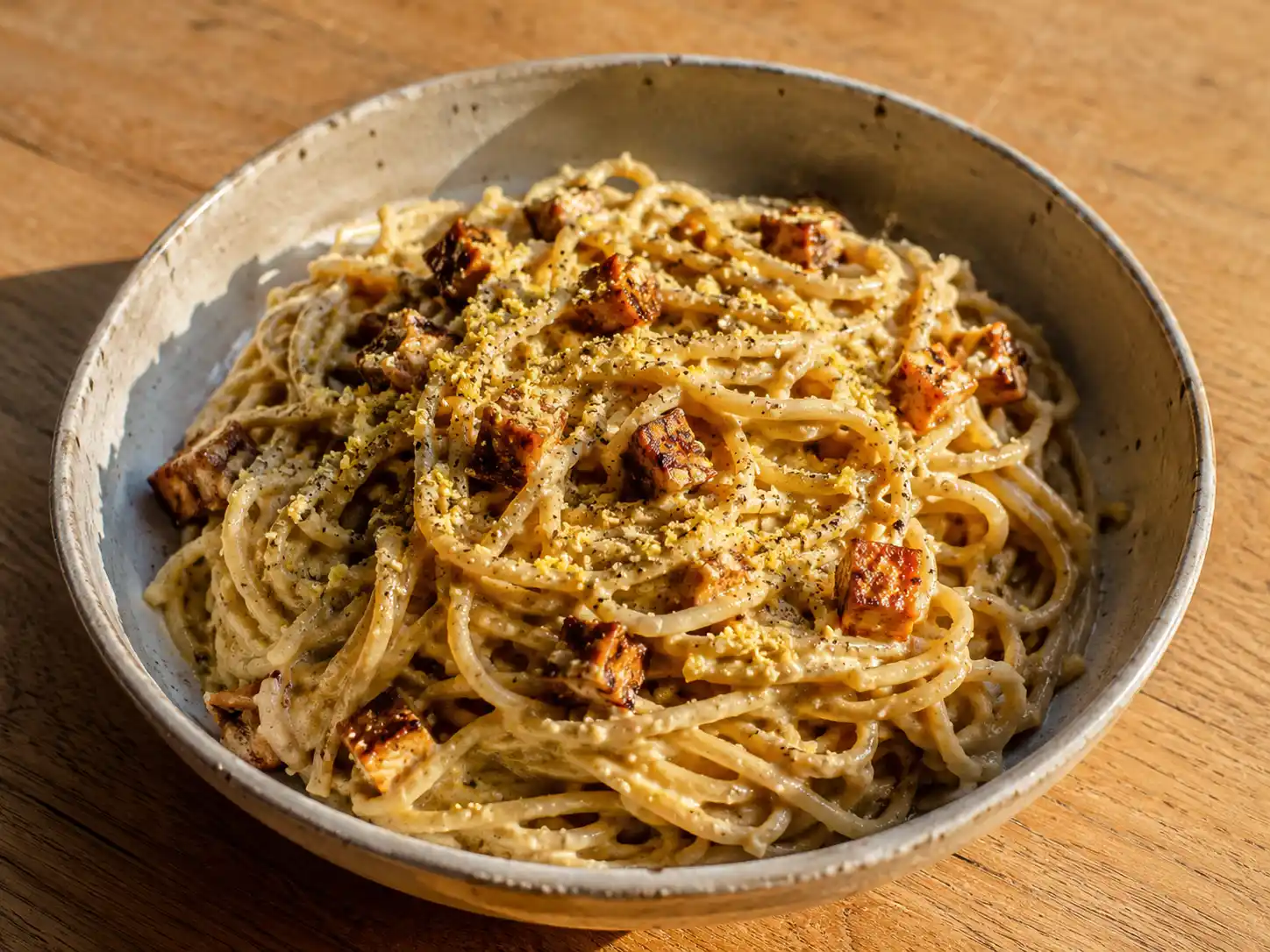 vegan carbonara med spaghetti, krämig tofusås, rökig tofu, näringsjäst och grov svartpeppar